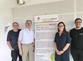 Die anwesenden Mitglieder des Grünen Netzwerks Bosco stehen um ein Transparent mit dem Titel Ihr ENGAGEMENT.